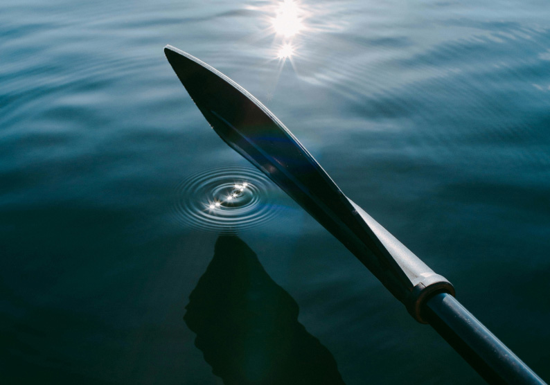 Oar in ocean creating ripples